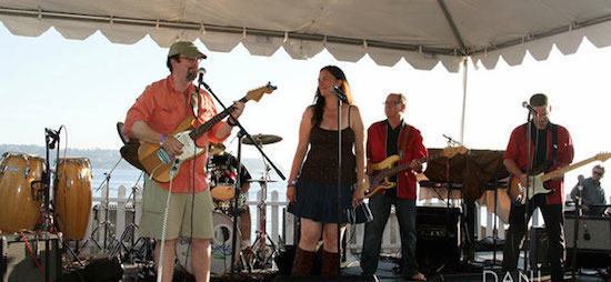 The Turbo Grape Stompers, led by Gordy Rawson of Chatter Creek Winery in Woodinville, are set to perform for the seventh straight year at Wine Rocks Seattle on July 10. Band members, left to right, are  singer/guitarist Les Campbell, drummer Tyke Kuhlmann, singer Mish Kriz, Rawson, and guitarist Bruce Taylor. (Photo by Dani Weiss Photography/Courtesy of Wine Rocks Seattle)