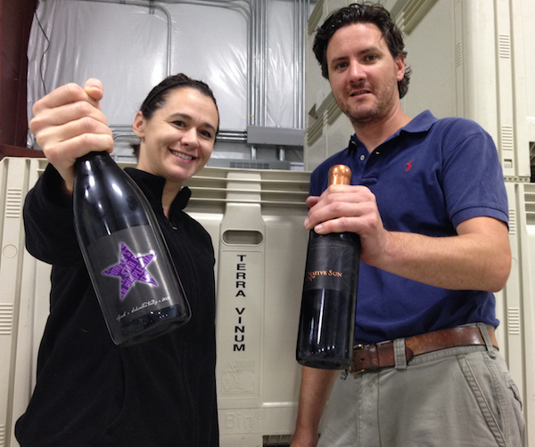 Amy Johnson presents a bottle of Purple Star Wines while Kyle Johnson holds a bottle of Red Mountain-based Native Sun.