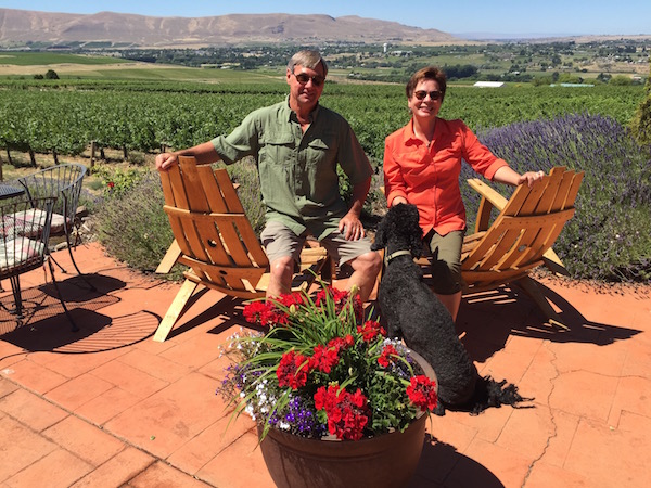 Larry Pearson and his wife, Jane, entertain Hugo, the youngest of their two standard poodles, on their Red Mountain patio at Tapteil Vineyard and Winery in Benton City, Wash.