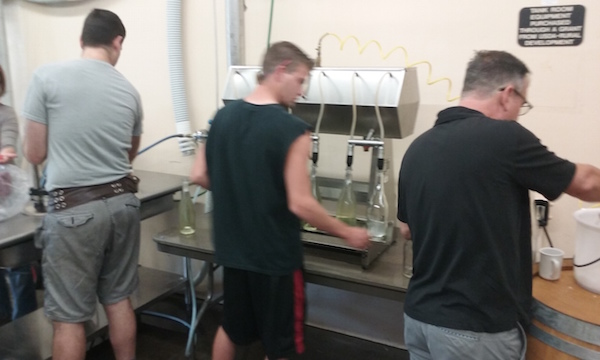 Students in the winemaking program Walla Walla Community College pull a shift on the bottling line at College Cellars before class starts as they cap the College Cellars 2015 Inland Desert Nursery Vineyard Muscat from the Yakima Valley.