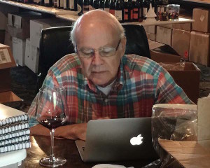 Ken Robertson, chief of judges at the 2015 Great Northwest Invitational Wine Competition, reviews a wine moments after it was awarded a gold medal by one of the five judging panels at the historic Columbia Gorge Hotel in Hood River, Ore.