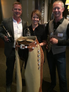 Will Mercer, winemaker Jessica Munnell, and owner Rob Mercer celebrate some of their recent successes, which include Wine Press Northwest 2016 Washington Winery of the Year and a pair of championship chaps from the Houston Livestock Show and Rodeo International Wine Competition. (Photo by Eric Degerman/Great Northwest Wine)