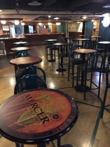 The Mercer Estates Wine Bar at KeyArena includes barrel-themed bistro tables across a floor reminiscent of a basketball court.