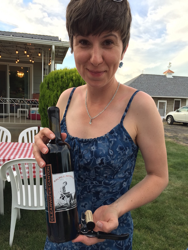 Coco Umiker, winemaker for Clearwater Canyon Cellars, celebrates the 100th anniversary of her family farm with a bottle of the 2013 Heritage Series Ralph E. Nichols Red Wine, named for her late grandfather. (Photo by Eric Degerman/Great Northwest Wine)